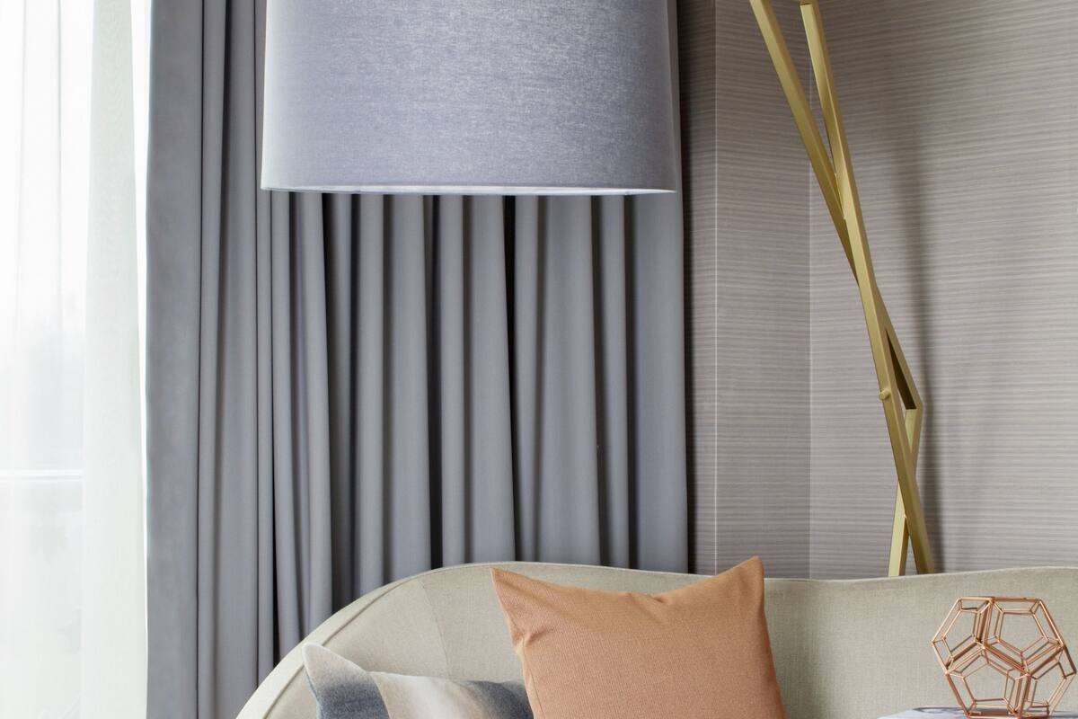 Ein modernes Wohnzimmer mit einer Couch, einer Lampe und einem Beistelltisch.