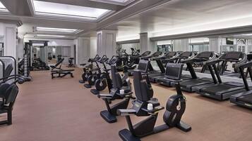 A gym with multiple treadmills, elliptical machines, and weight machines.
