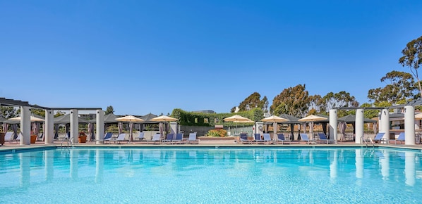 Una piscina al aire libre, sillones reclinables de piscina