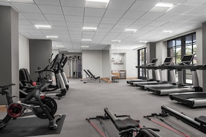 A gym with various exercise equipment, large windows, and a clean, modern design. - Hyatt Regency La Jolla (San Diego)
