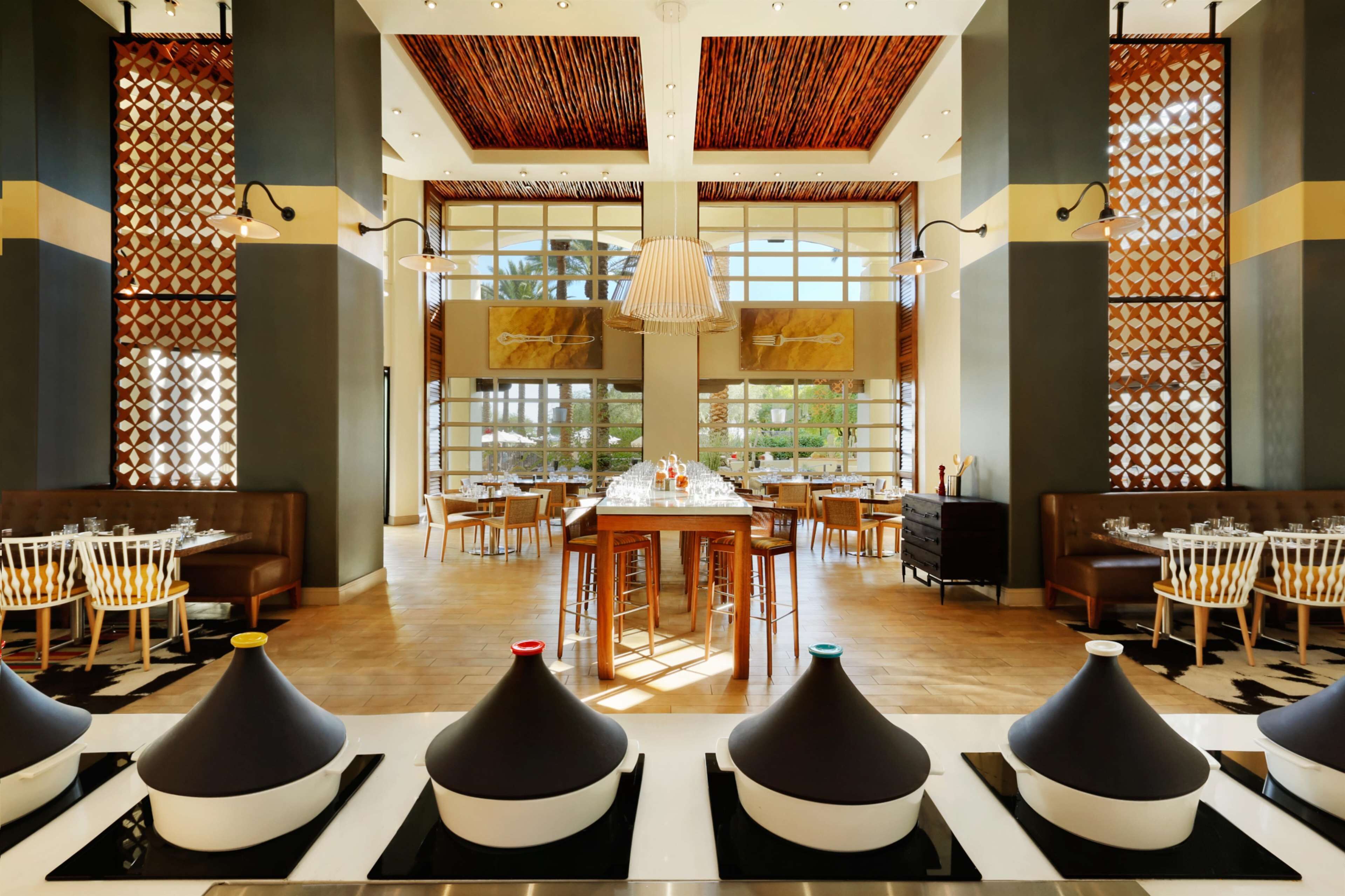 A spacious dining area with high ceilings, large windows, and modern decor.