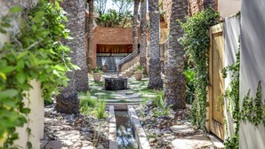 A narrow courtyard with a water feature, stone steps, and a brick wall. - Fairmont Scottsdale Princess (Scottsdale)