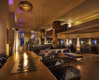 Two people practicing aerial yoga in a room with wooden floors and large windows. at Fairmont Scottsdale Princess