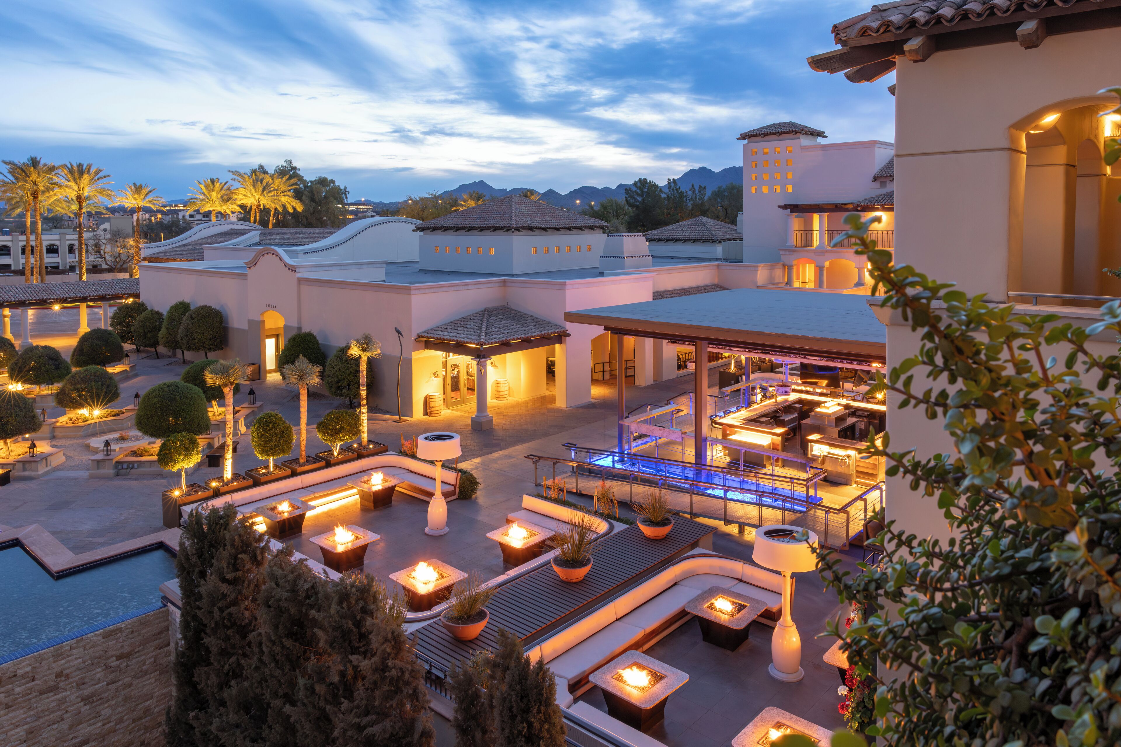 A resort with outdoor seating areas, a pool, and a bar/lounge area.