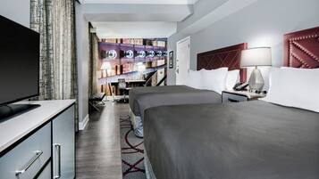 Una habitación de hotel con televisión, dos camas, escritorio y baño.