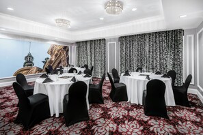 A conference room with round tables, black chairs, and a patterned carpet. - Hotel Indigo Dallas Downtown by IHG (Dallas)