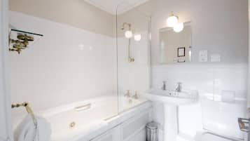 Un baño moderno con bañera, lavamanos e inodoro.