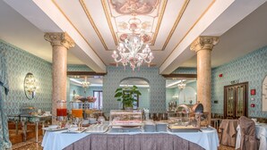 Uma sala de jantar formal com lustre, teto trabalhado e colunas clássicas.