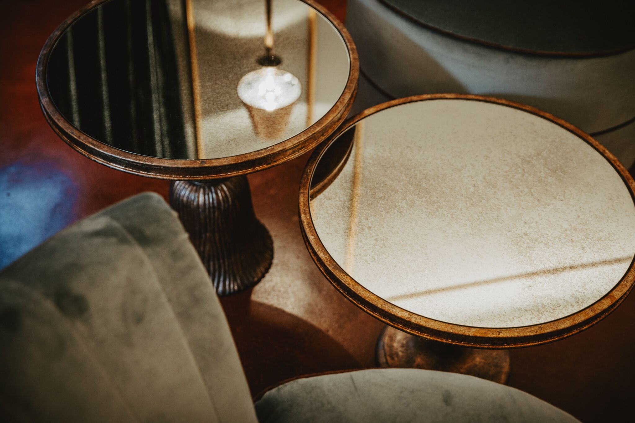 Two round mirrors with wooden frames on a table.