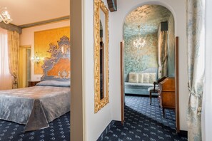 A hotel room with a large bed, a decorative mirror, a chandelier, and a sofa. - Hotel Giorgione (Venice)