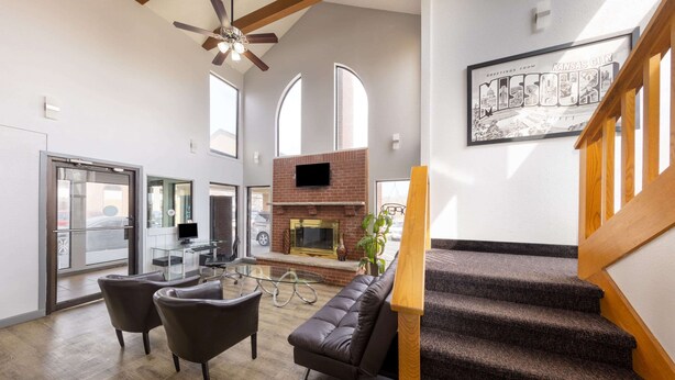 A spacious living area with a fireplace, comfortable seating, and a staircase.
