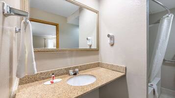 A bathroom with a granite countertop, a white sink, a mirror, a towel rack, and a shower curtain.