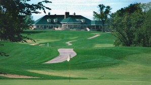A golf course with a clubhouse in the background.
