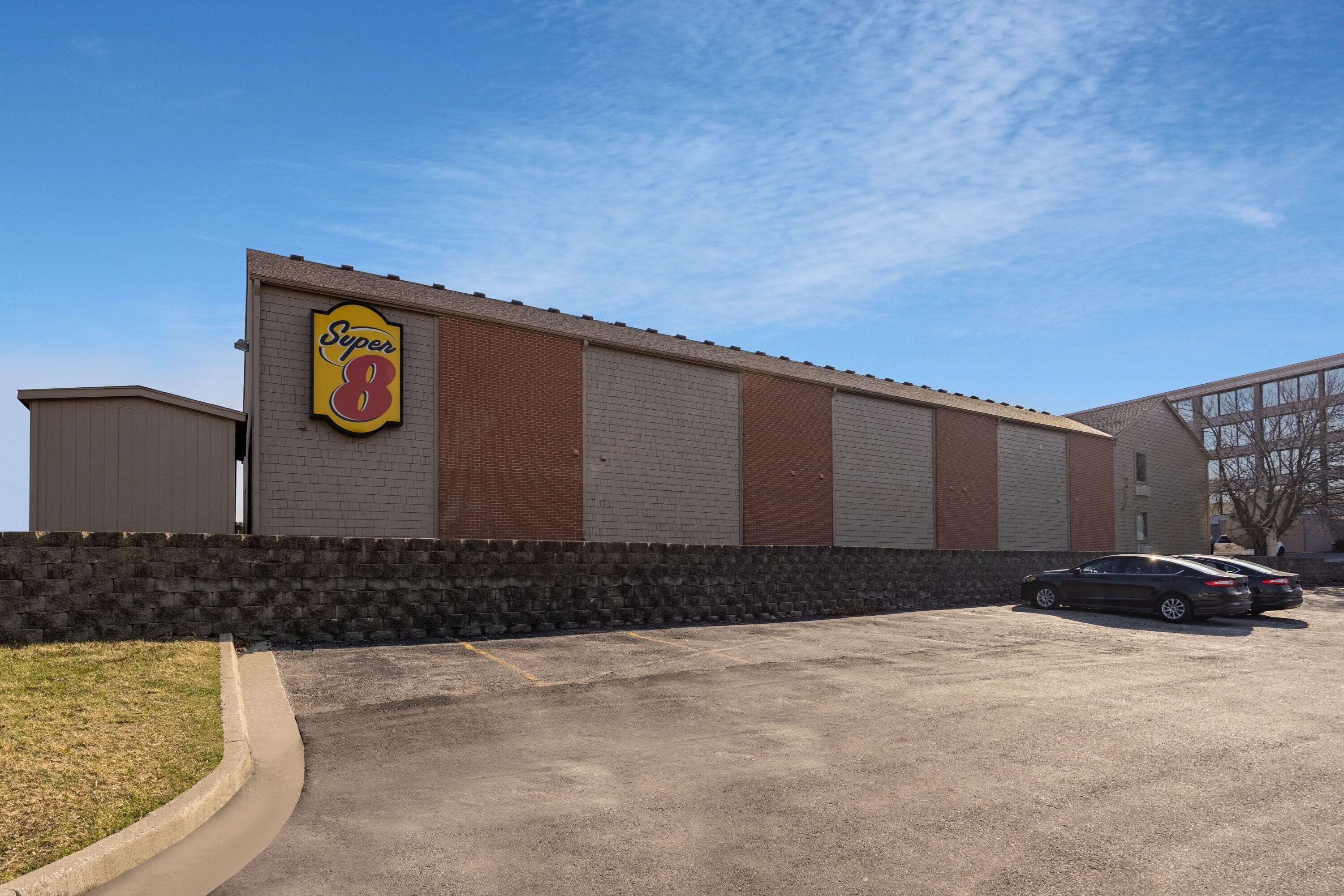 A Super 8 motel with a brick facade and a parking lot.