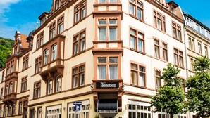 A multi-story hotel with a prominent corner tower, large windows, and a sign for "Heidelberg." - The Heidelberg Exzellenz Hotel (Heidelberg)