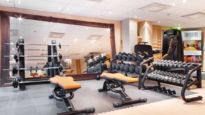 A gym with weightlifting equipment, benches, and a mirror. - Scandic Park Helsinki (Helsinki)