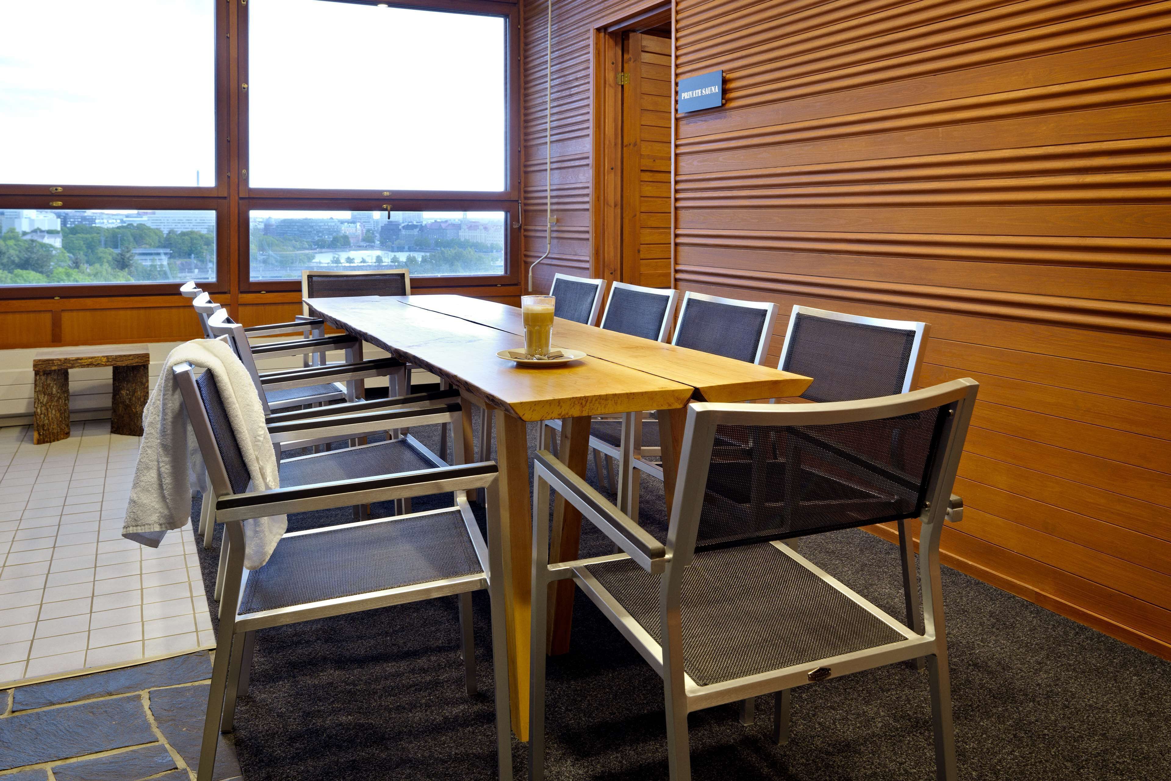 Une salle de conférence avec une longue table, six chaises et une grande fenêtre donnant sur la ville.