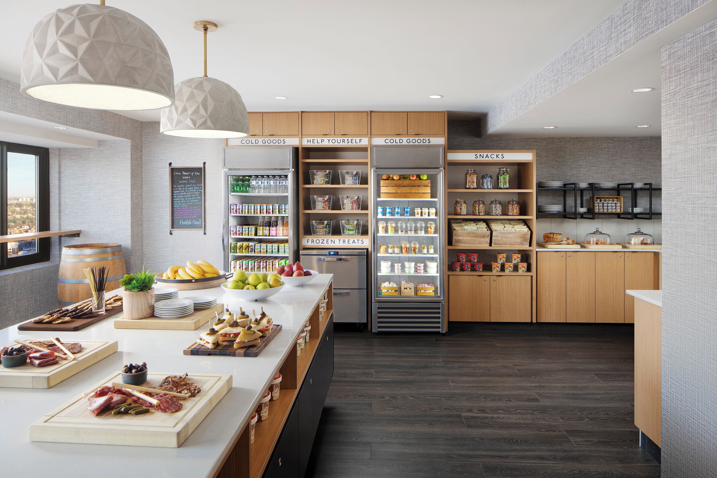Una cocina moderna con armarios de madera, una isla central con alimentos y un refrigerador con la etiqueta 'FROZEN TREATS'.