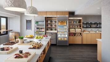 Una cocina moderna con armarios de madera, una isla central con alimentos y un refrigerador con la etiqueta 'FROZEN TREATS'.
