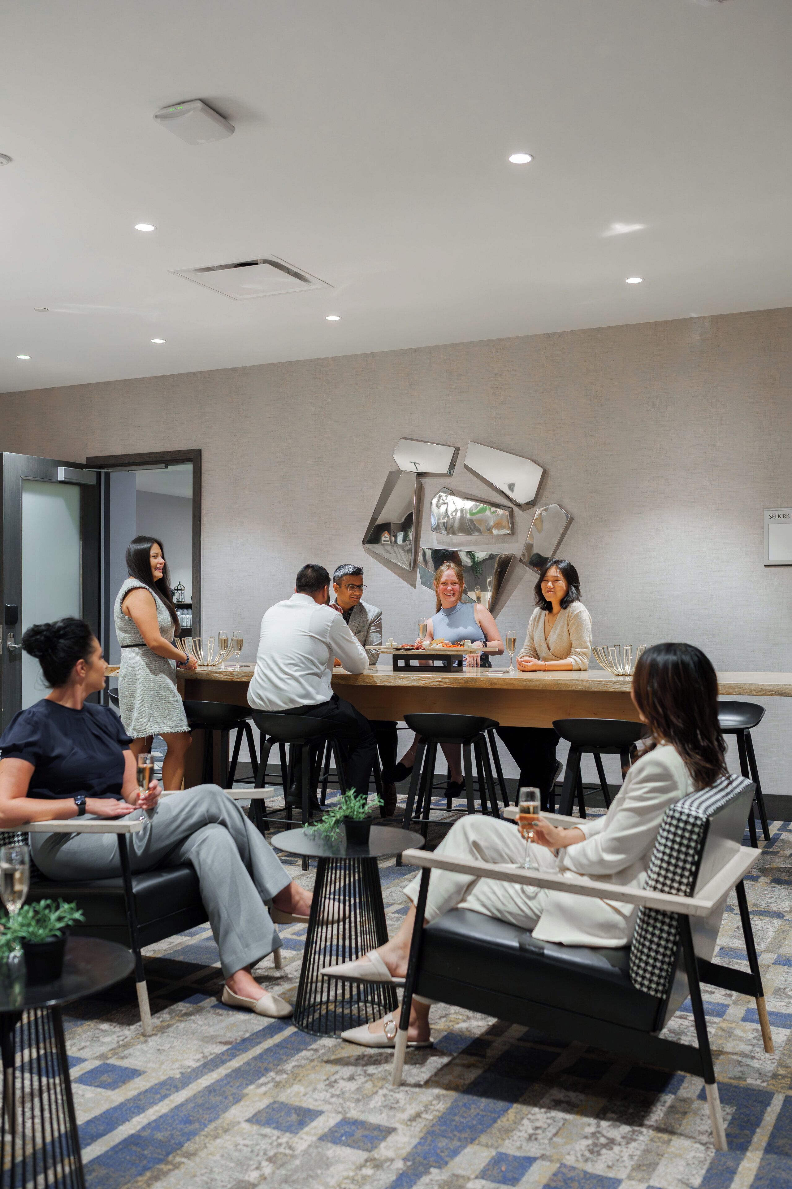A conference room with a long table, several chairs, and a modern ceiling design.
