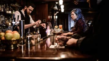 A bar with a bartender preparing drinks.