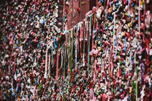 A wall covered with colorful, hanging objects.