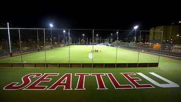 Ein Sportplatz im Freien mit großem Schriftzug 'SEATTLE' auf dem Rasen.