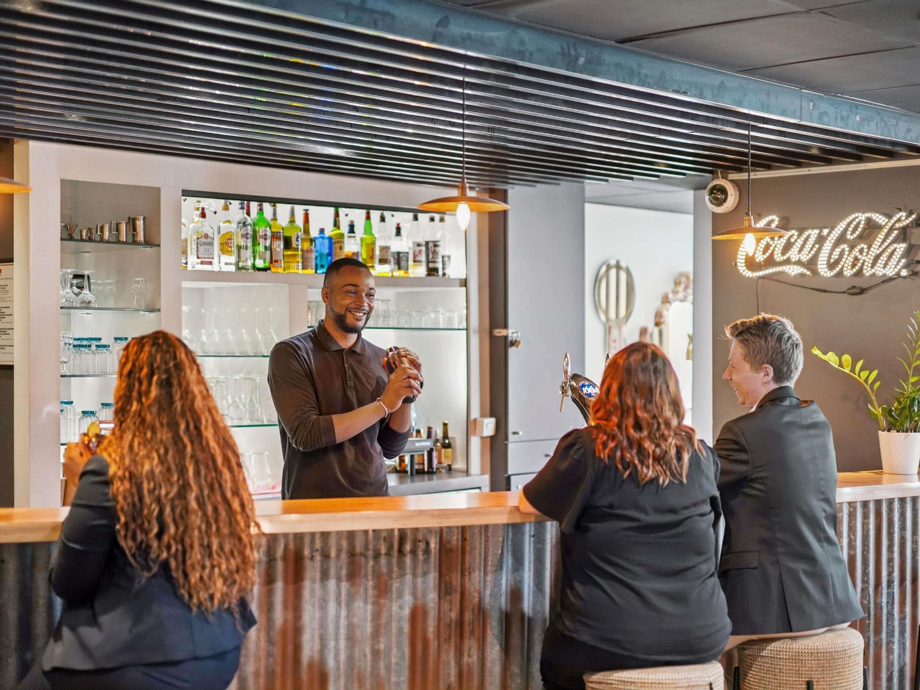 Una zona de bar con mostrador, estantes con botellas y un letrero de Coca-Cola.