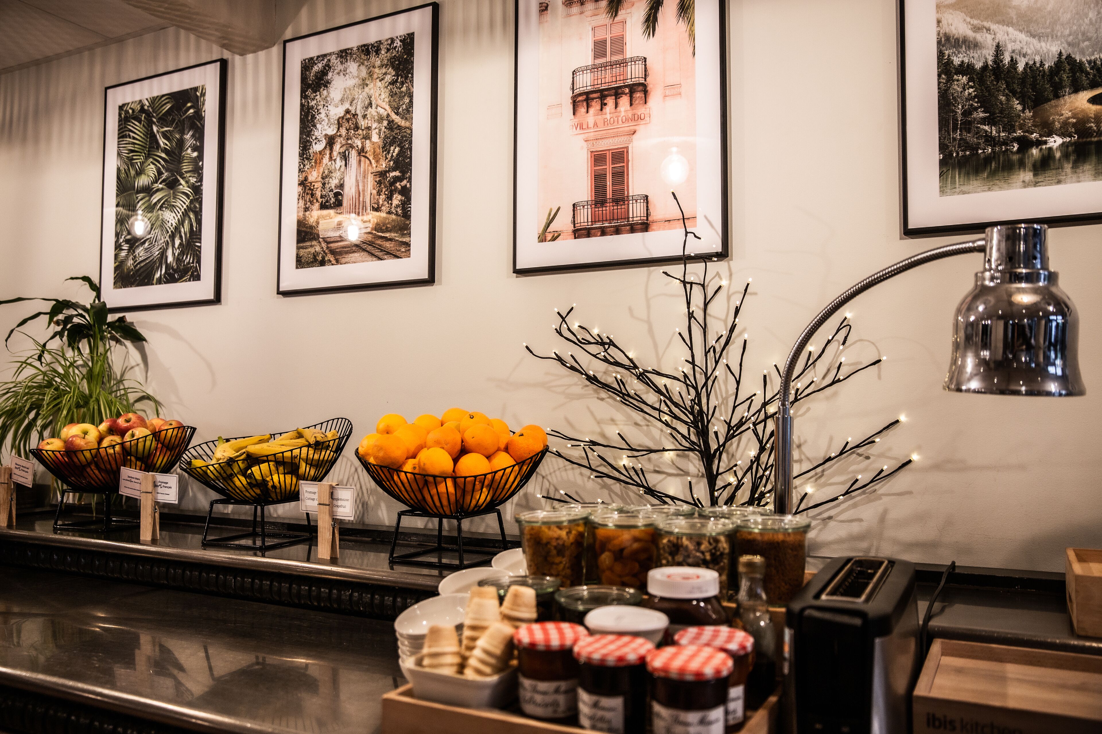 A buffet area with fruit bowls, condiments, and a lamp.