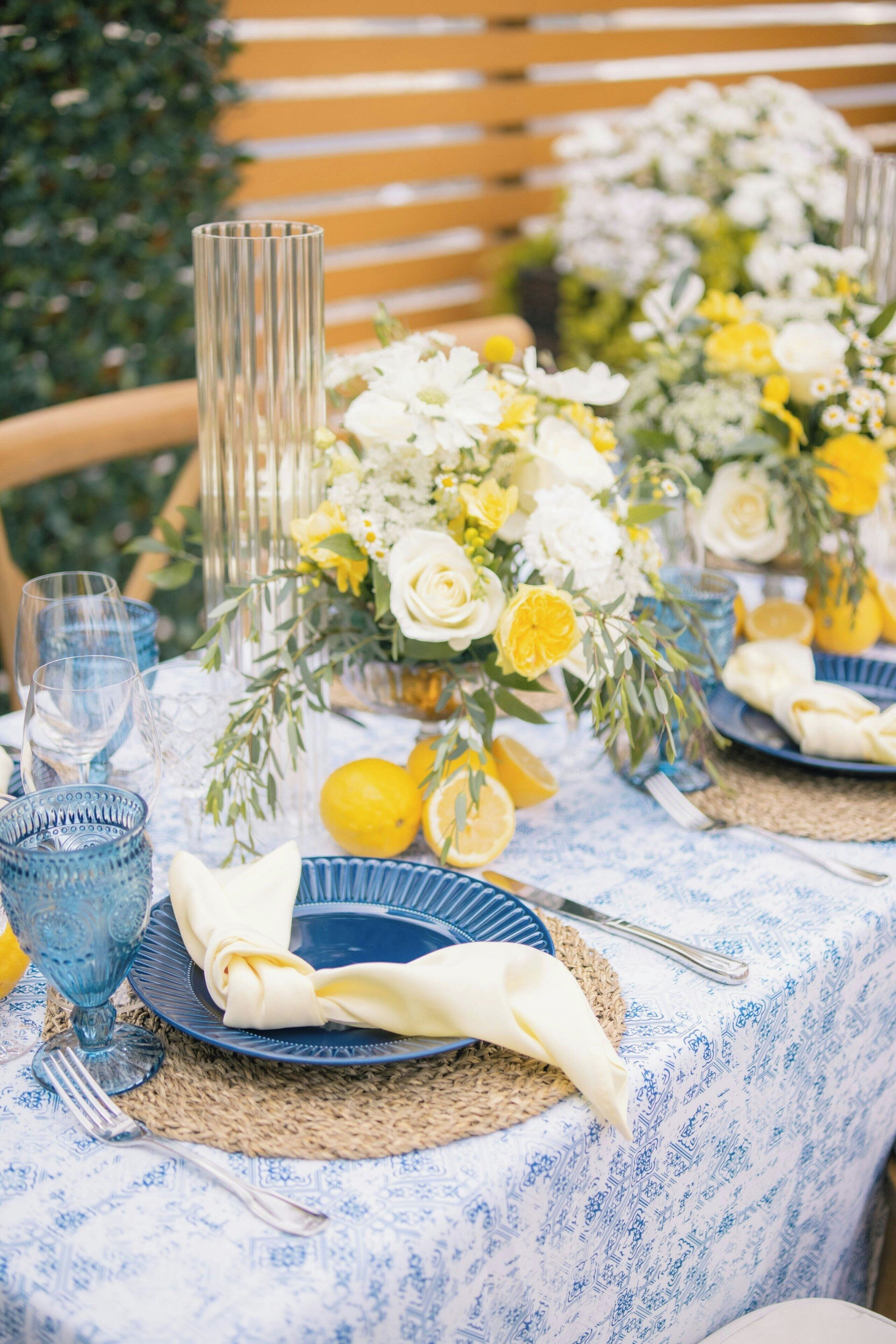 A table set with blue plates, a clear glass, and a woven placemat.