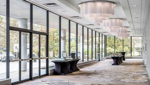 Un pasillo espacioso con ventanas amplias, suelo estampado e iluminación colgante moderna.