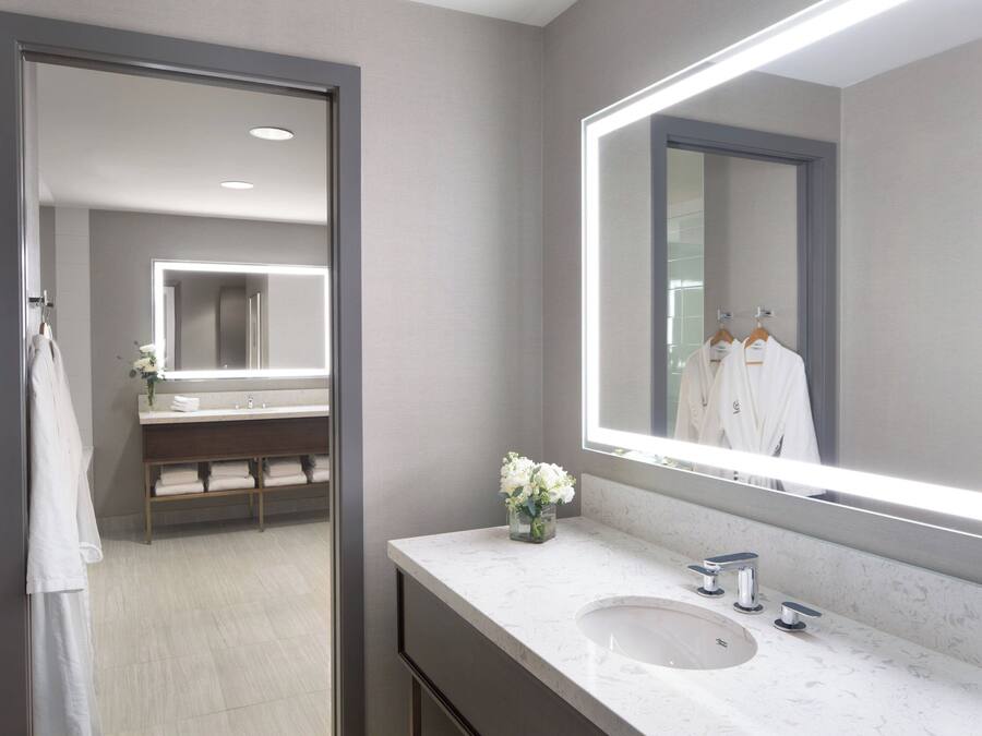 A modern bathroom with a large mirror, a sink, and a vanity.