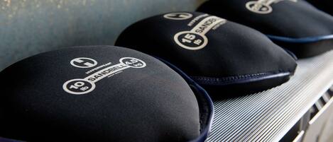 A shelf with three black caps labeled "Hyperwear" and "SANDBELT" with weight markings.
