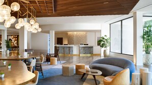 Een modern interieur met een houten plafond, een ronde tafel met stoelen, een bank en een groot raam.