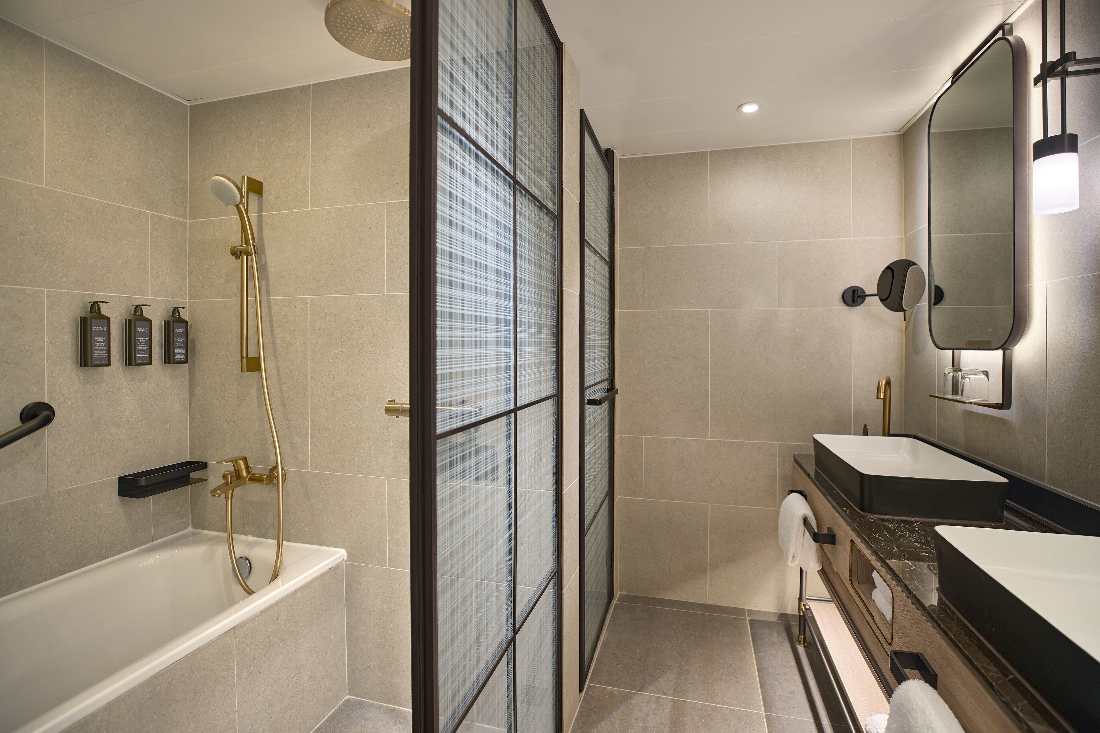 A modern bathroom with a bathtub, a glass-enclosed shower, and a vanity with a mirror.