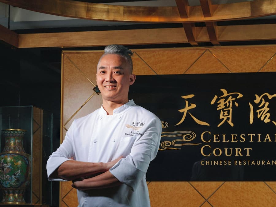 A chef standing in front of a sign for 'Celestial Court Chinese Restaurant'.