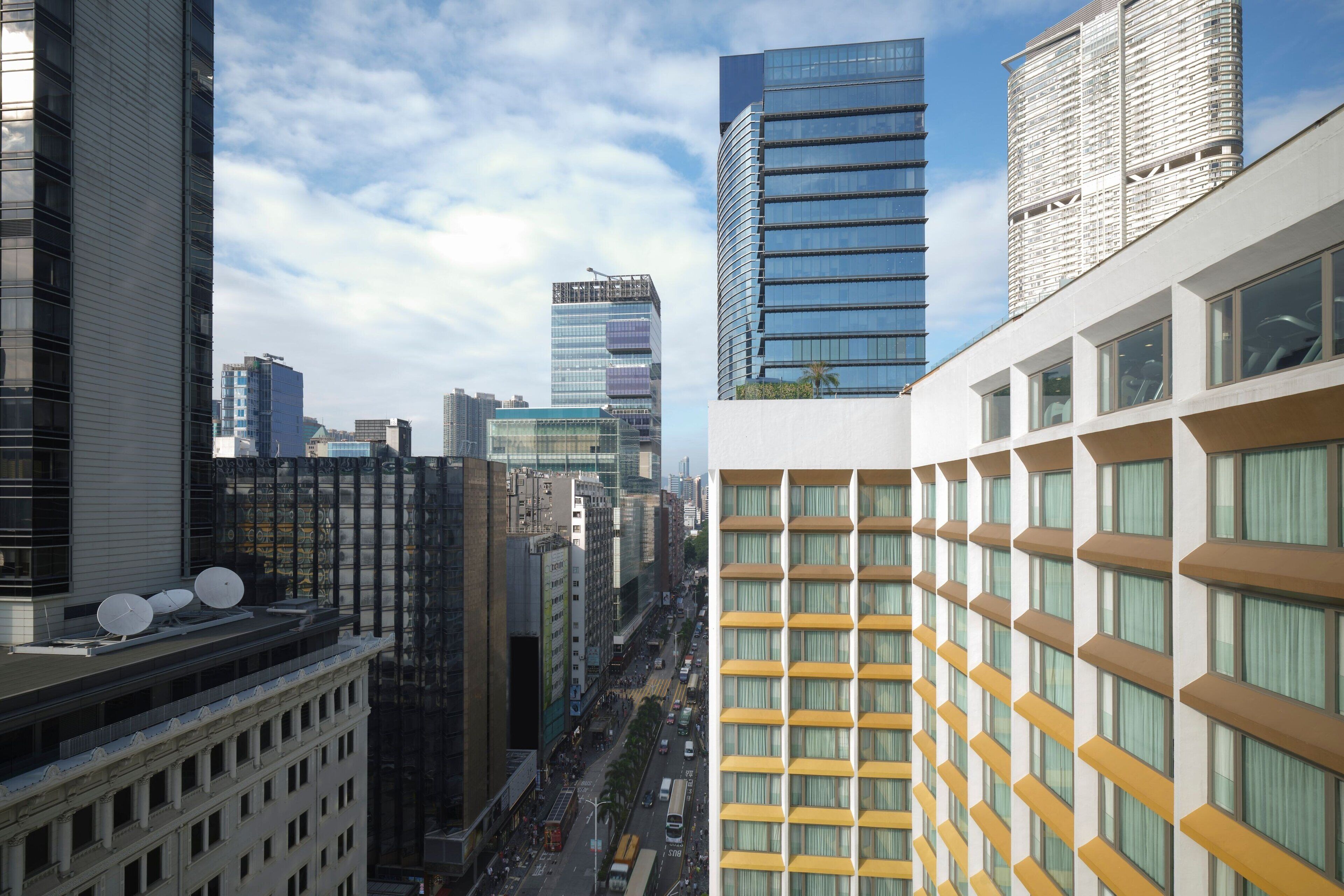 Um horizonte urbano moderno com edifícios altos, uma rua movimentada e uma variedade de estilos arquitetônicos.