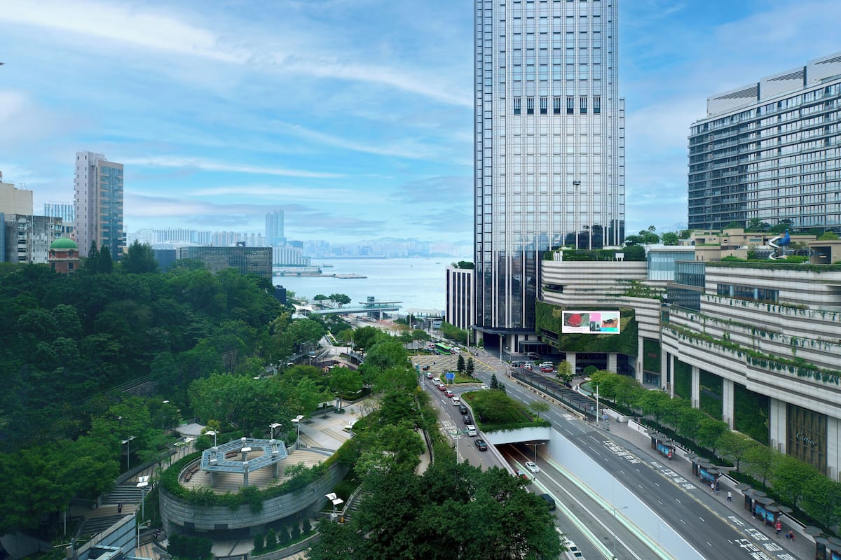 A modern urban area with high-rise buildings, a curved park, and a waterfront.