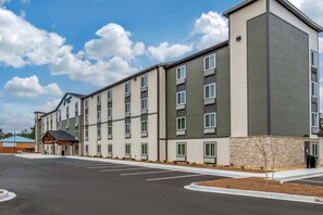 A multi-story hotel with a parking lot in front.