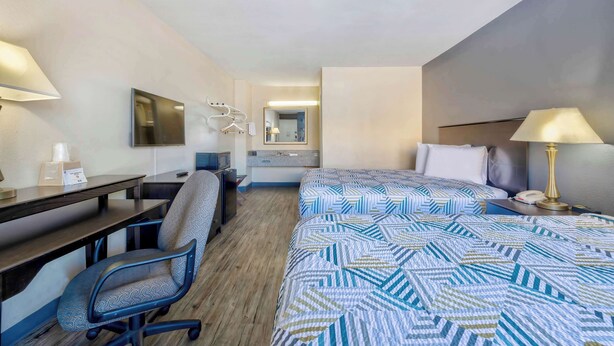A hotel room with a bed, desk, chair, and a mirror. - Motel 6 Effingham, IL (Effingham)