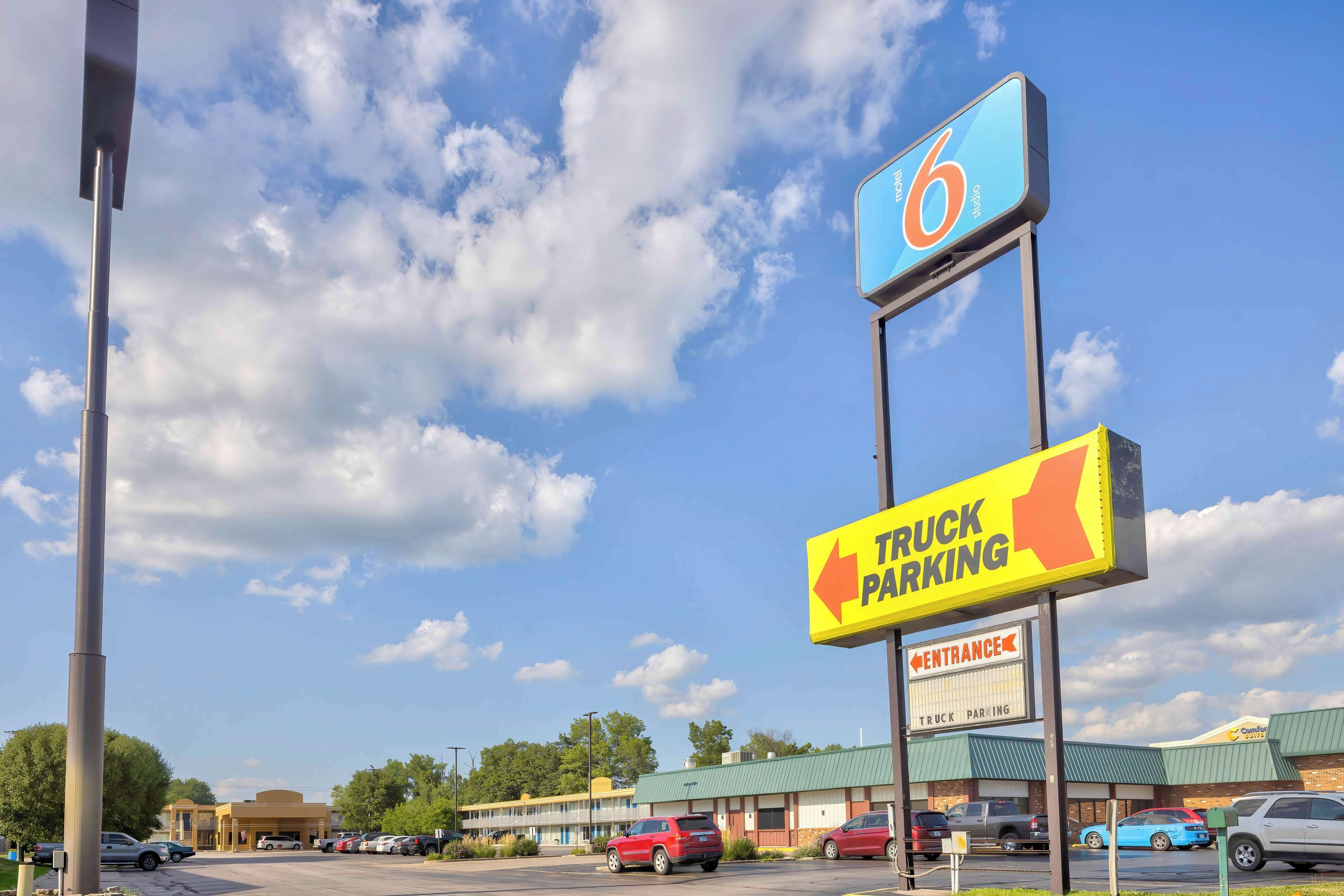 A truck parking area with a sign indicating the entrance direction.