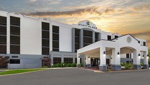 Un moderno hotel Hyatt Place con una entrada amplia y un área techada.