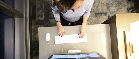 A person at a desk with a keyboard and a monitor displaying a website.