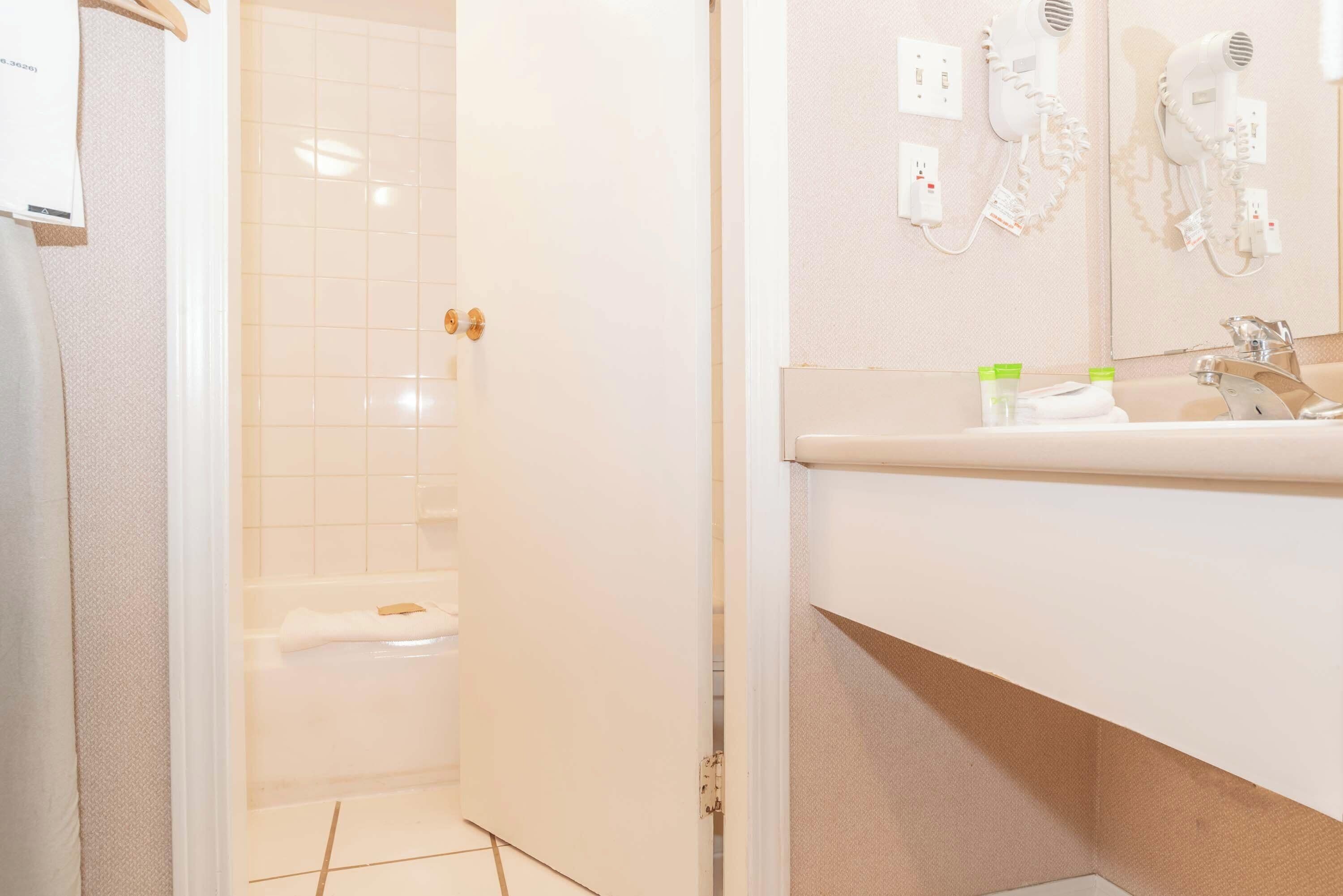 A bathroom with a shower, a sink, and a mirror.