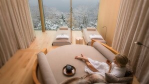 A spa room with a large window overlooking a snowy landscape.
