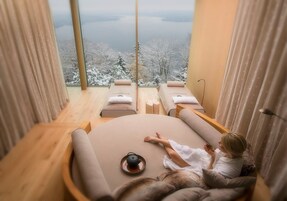 Un cuarto de spa con un amplio ventanal que da a un paisaje nevado.