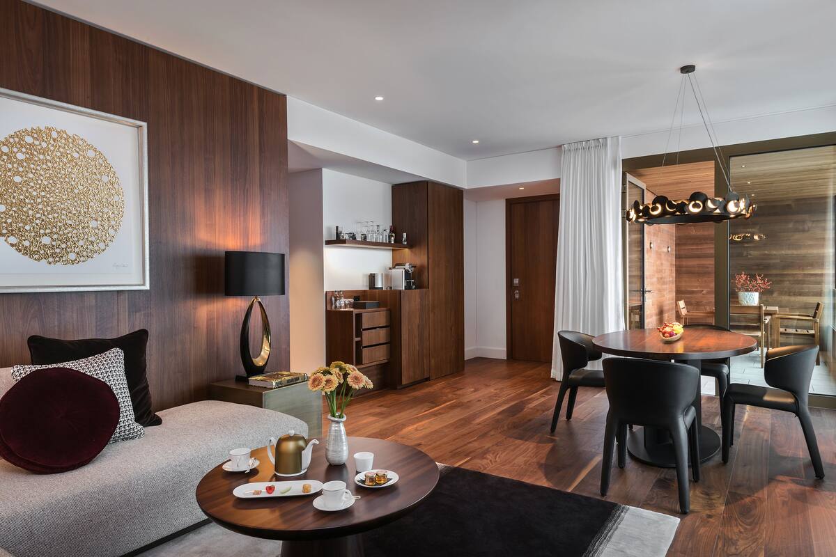 Uma sala de estar moderna com sofá, mesa de centro e área de jantar.