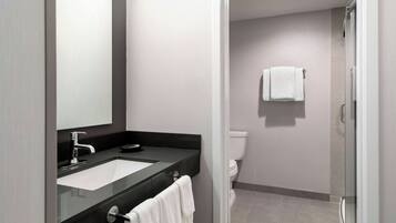 A modern bathroom with a sink, mirror, and toilet.