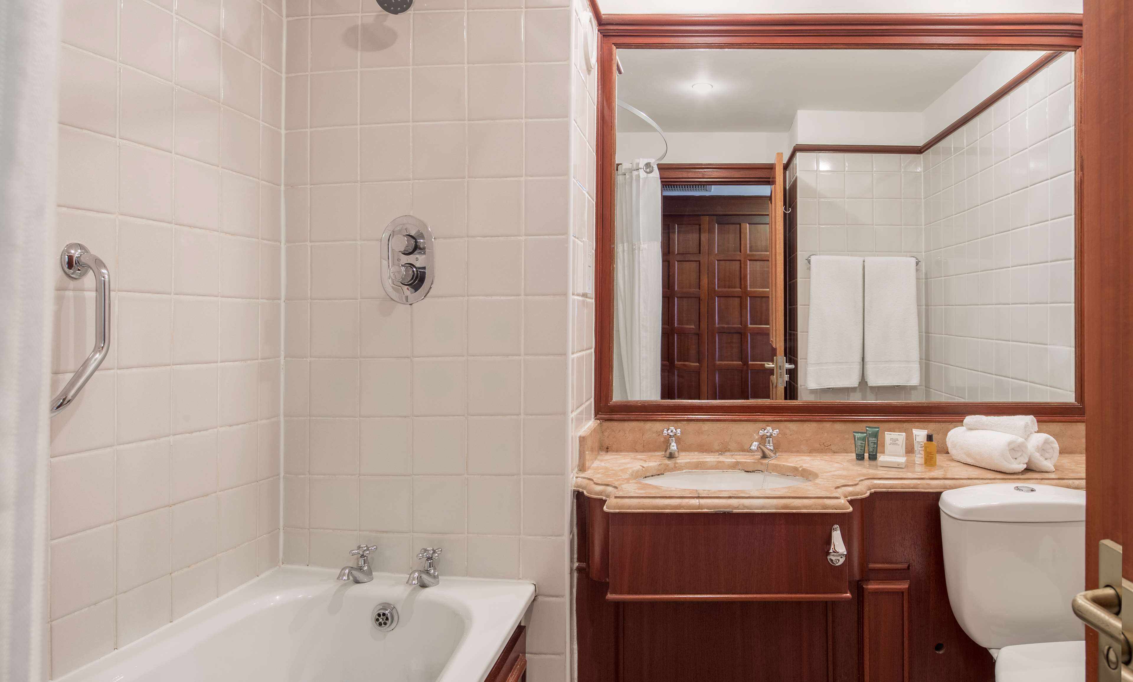A bathroom with a bathtub, a sink, and a toilet.