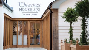 The entrance to Weaver's House Spa, featuring a wooden facade, stone steps, and a glass door. - The Swan Hotel (Sudbury)